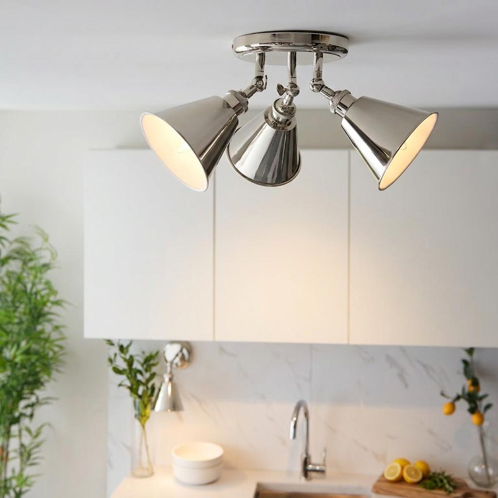 A Hal Nickel 3-light modern spotlight with polished nickel cone shades mounted on a white kitchen ceiling.