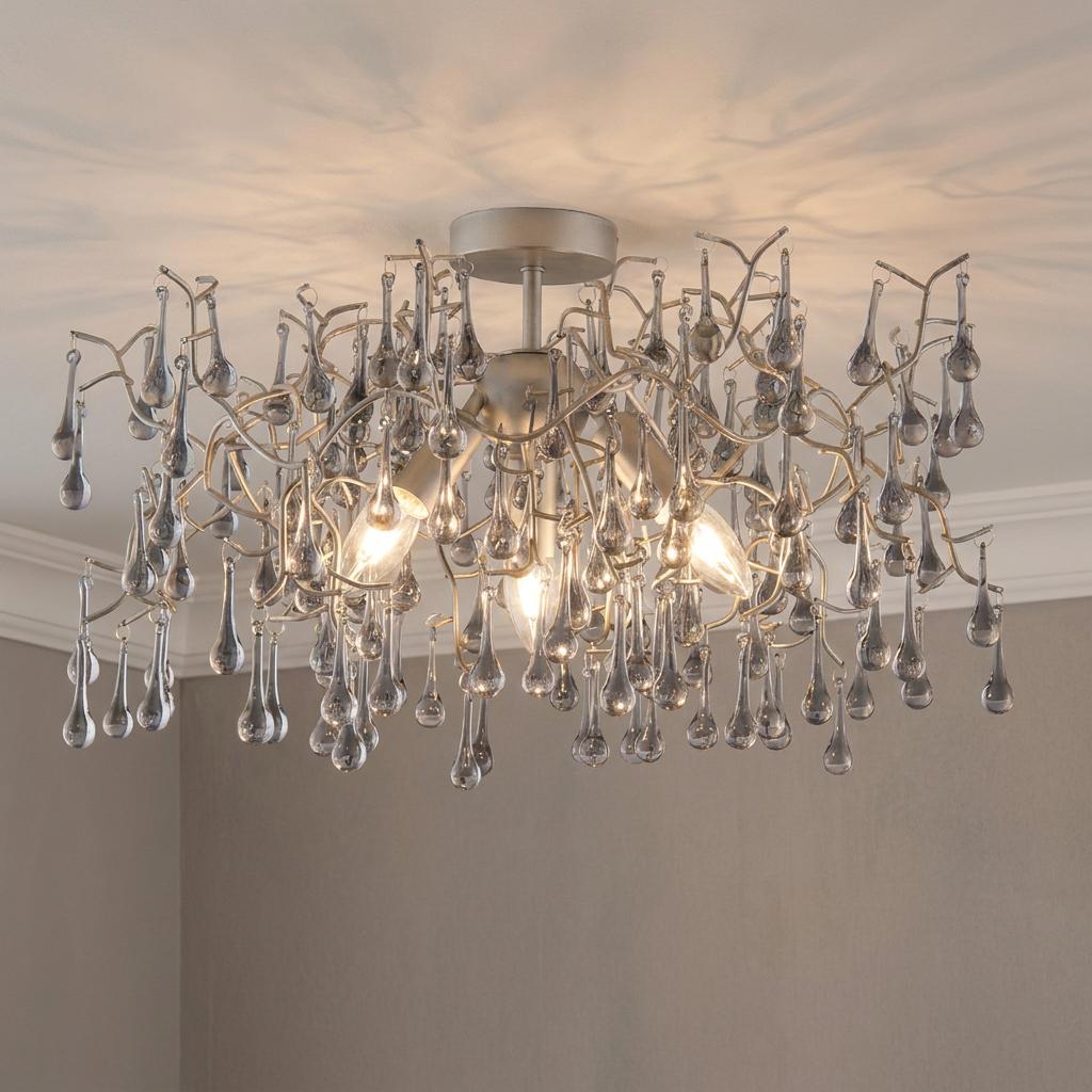 Silver semi-flush ceiling light with three glowing bulbs and cascading grey glass teardrops.