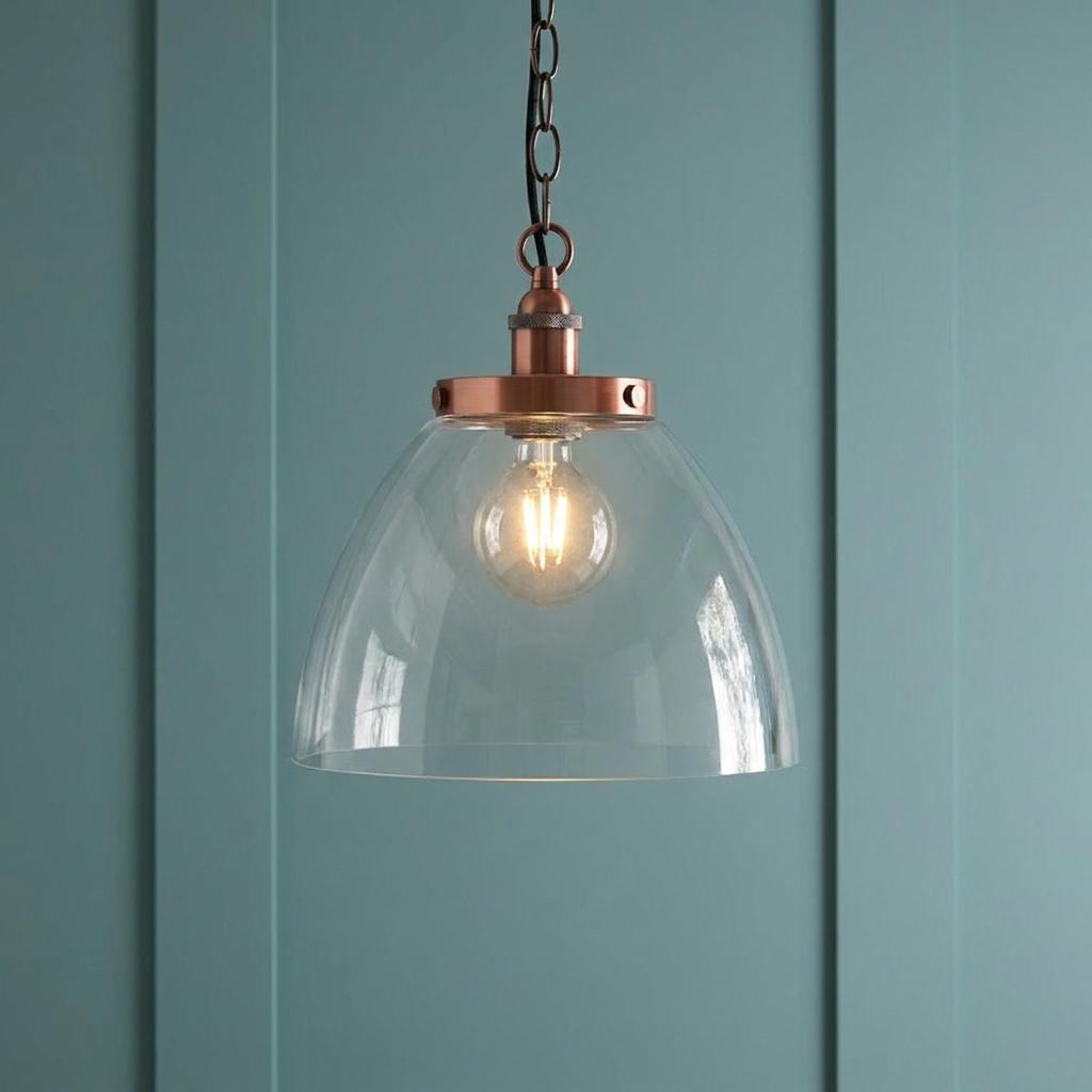 Hansen Grand Copper Pendant Ceiling Light with a clear glass dome shade against a teal paneled wall.