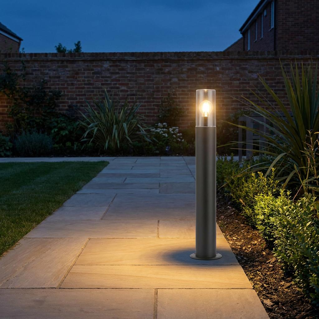 Hayden bollard light with a clear glass shade illuminating a stone patio path at dusk.