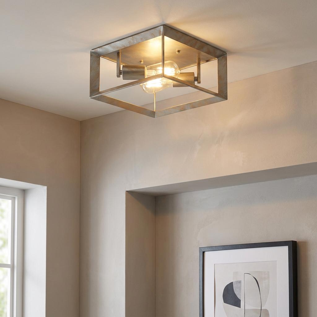 Industrial square flush ceiling light with a brushed silver and gold metal frame and two glowing filament bulbs.
