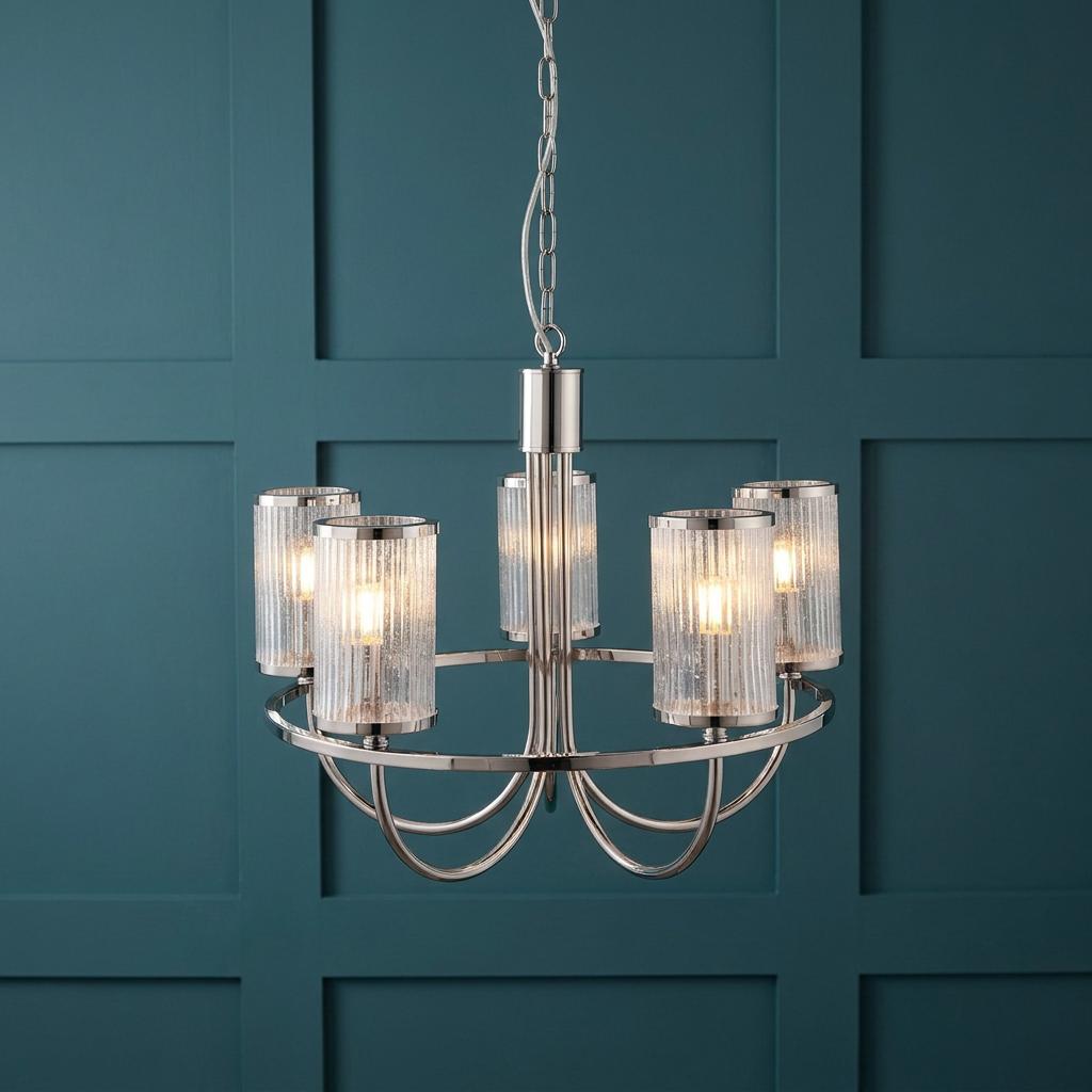 Henbury 5-light nickel pendant with ribbed glass shades illuminated against a teal paneled wall.