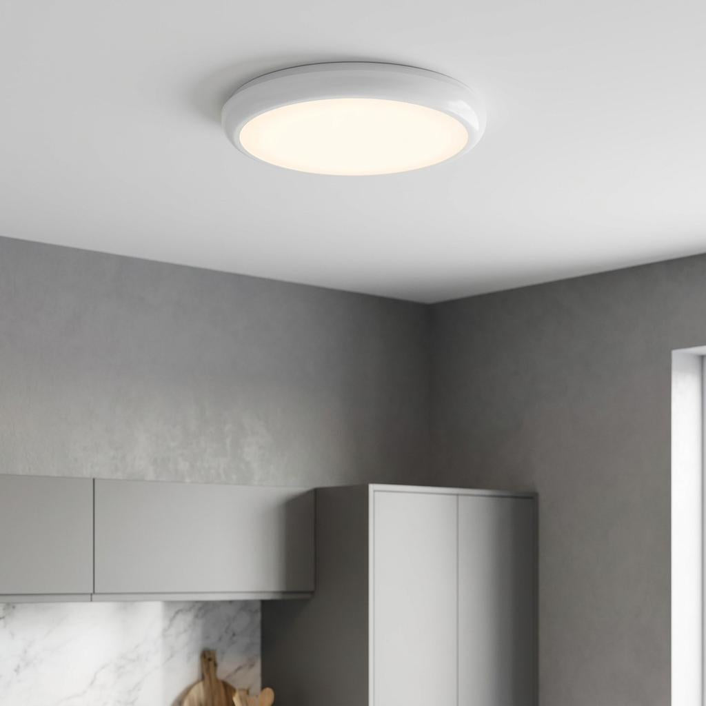 Round HeroPro XL LED flush light mounted on a white ceiling, providing warm light in a modern kitchen.