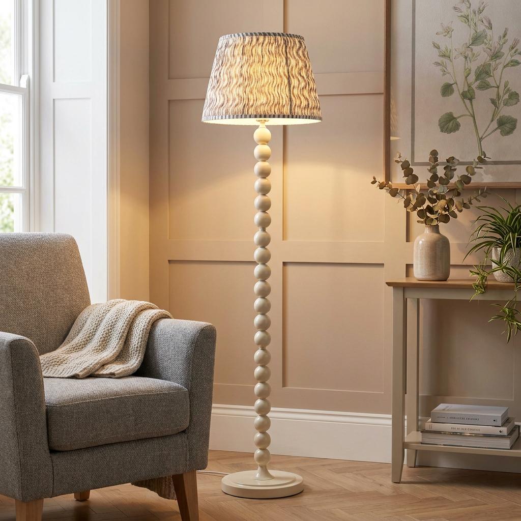 Almond white beaded floor lamp with a ripple pearl grey shade in a cozy, paneled living room.