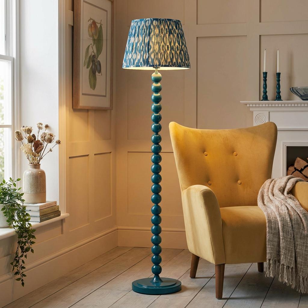 Blue bobbin floor lamp with an ikat Marlin blue shade next to a yellow wingback armchair in a living room.