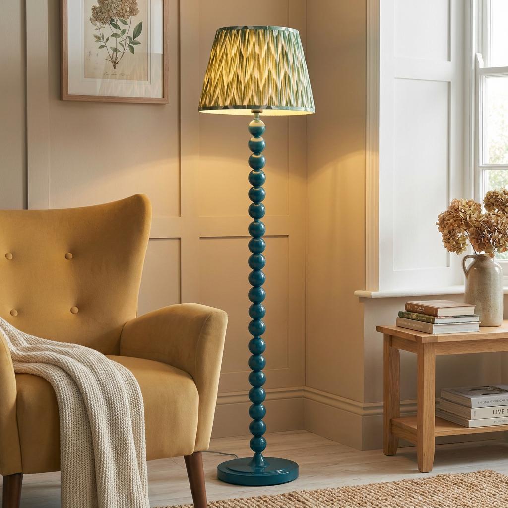 Higgledy blue bobbin floor lamp with a green zigzag shade in a cozy living room next to a yellow armchair.