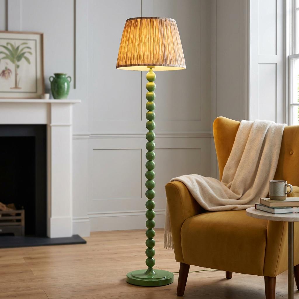 Green bobbin floor lamp with an ikat shade stands next to a yellow armchair in a modern living room.