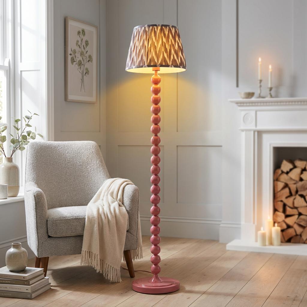 Higgledy Pink Floor Lamp with a zigzag shade stands in a cozy living room by a grey armchair.