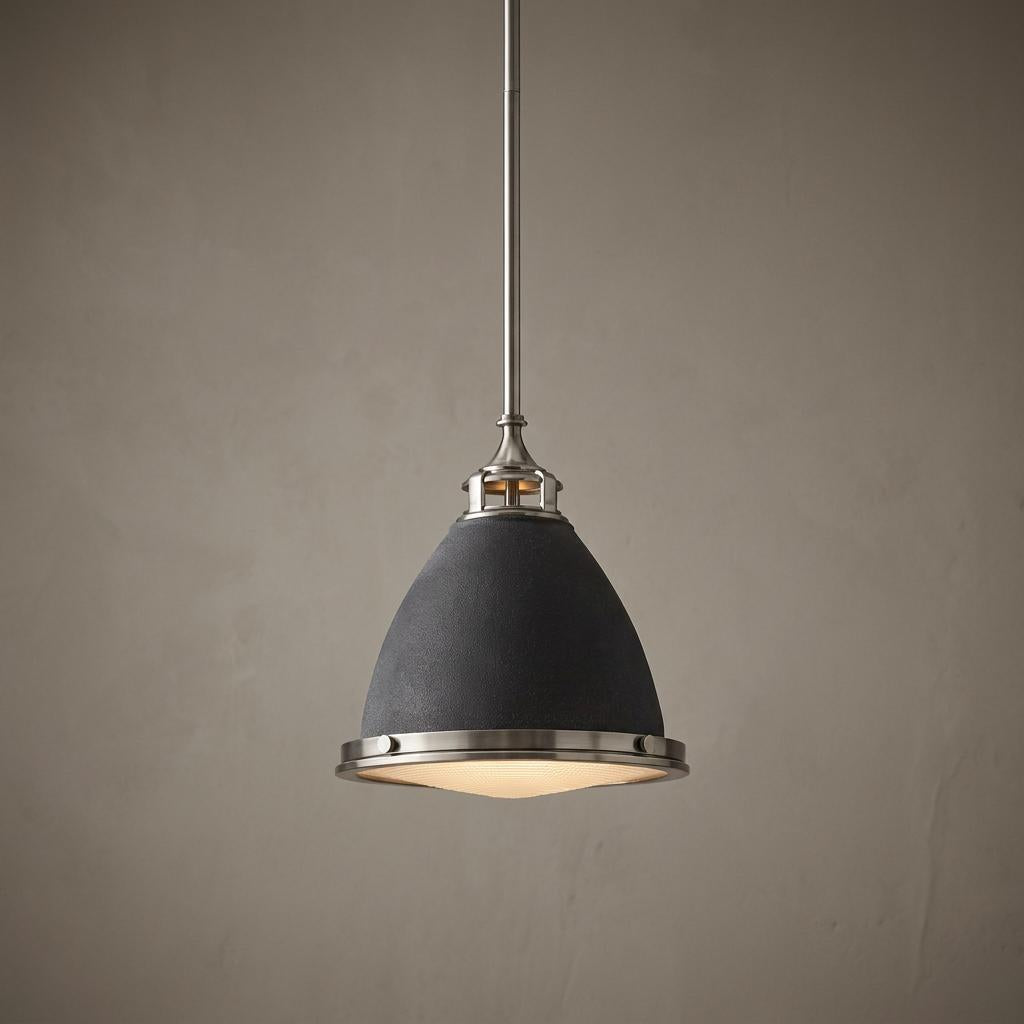 Bell-shaped aged zinc pendant light with brushed metal trim hanging against a neutral background.