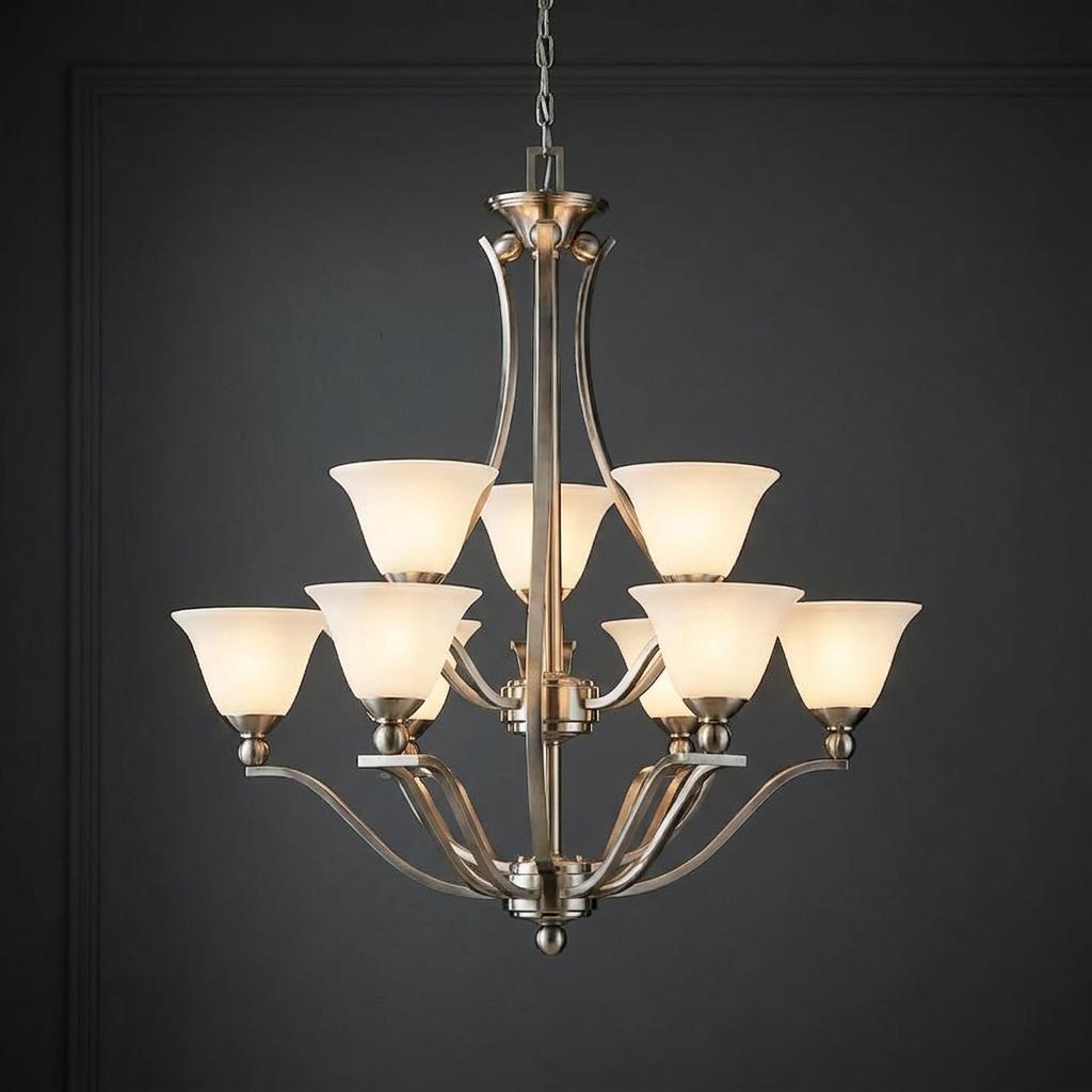 Nine-light brushed nickel chandelier with opal glass shades against a dark charcoal paneled wall.