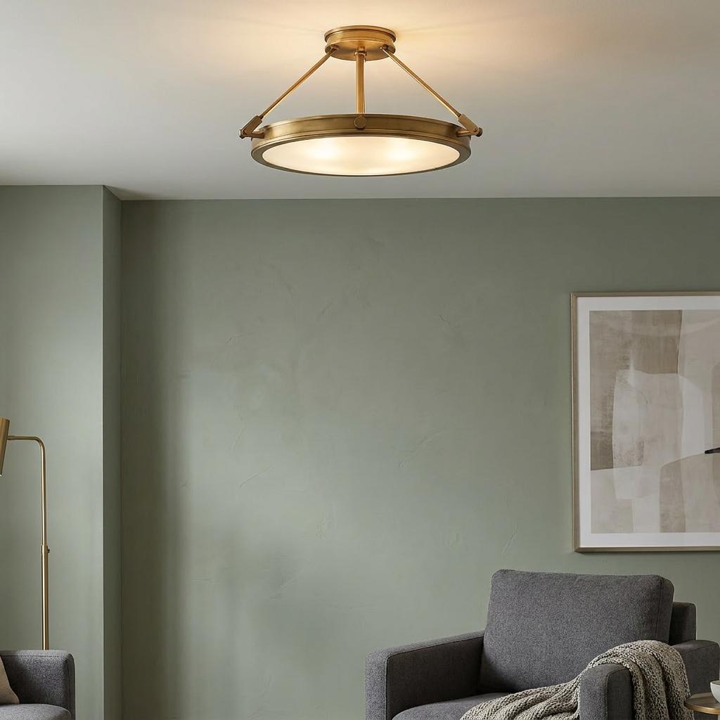 A Hinkley Collier brass semi-flush ceiling light illuminates a modern living room with sage green walls.