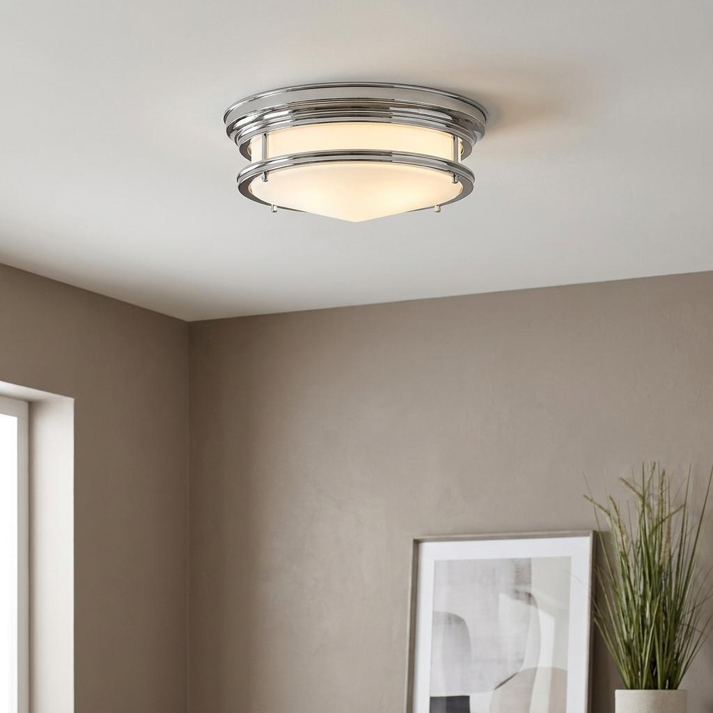 Art Deco chrome flush mount ceiling light with a frosted glass shade illuminated in a neutral room.