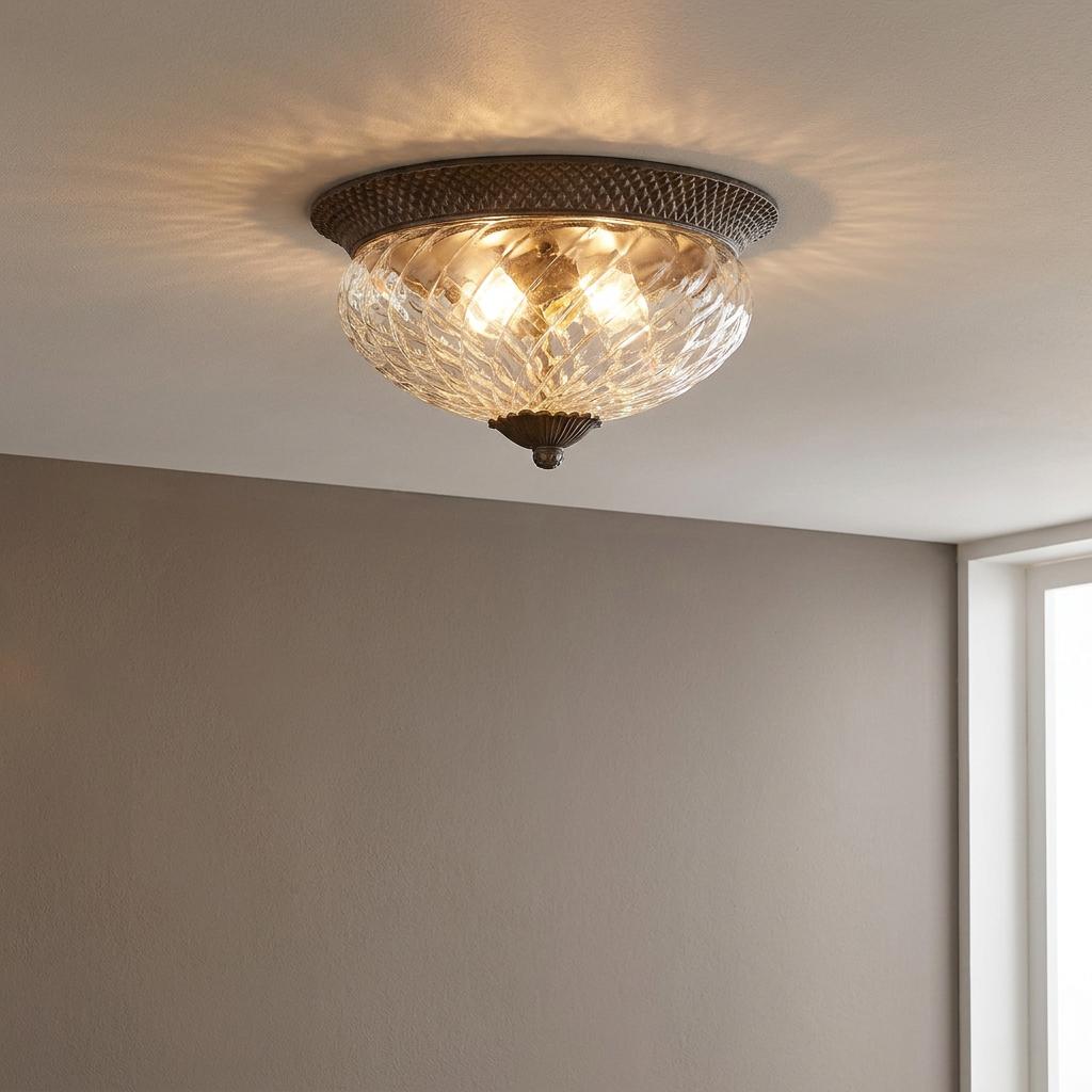 Hinkley Plantation bronze flush ceiling light with pineapple-patterned glass shade casting light onto a white ceiling.
