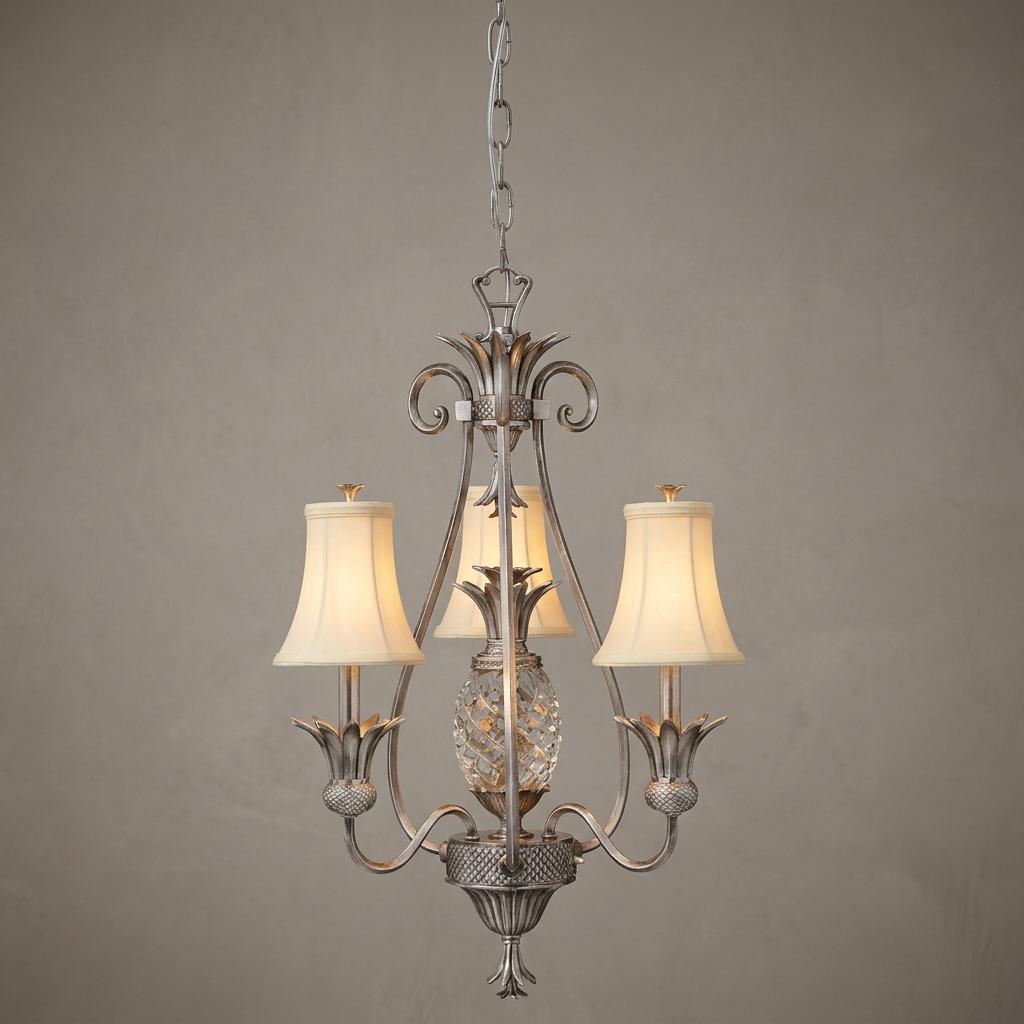 Three-light chandelier with pineapple motifs in polished antique nickel featuring three cream fabric shades.