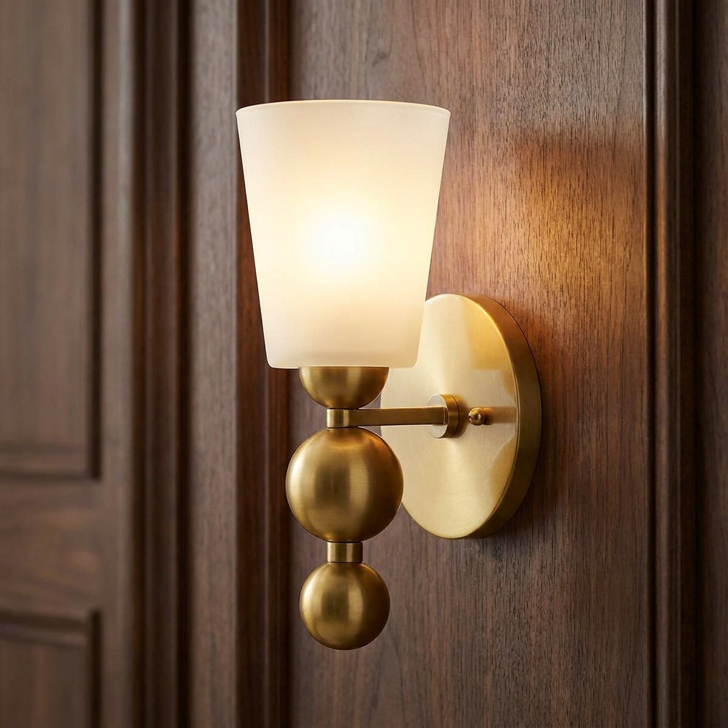 Vintage brass wall sconce with a frosted glass shade and orb accents, mounted on a dark wood-paneled wall.
