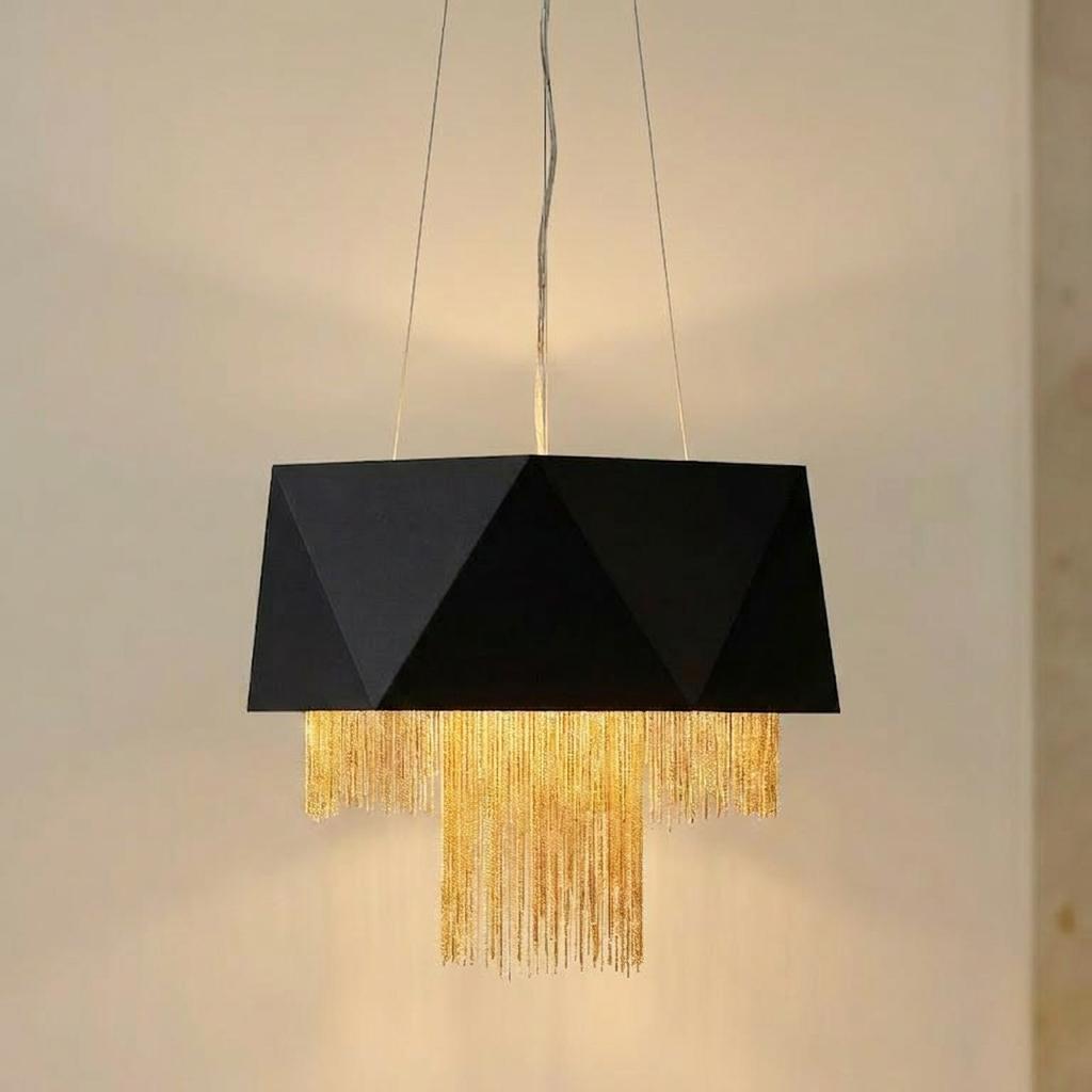 Black faceted pendant light featuring a tiered gold chain fringe suspended from a ceiling.