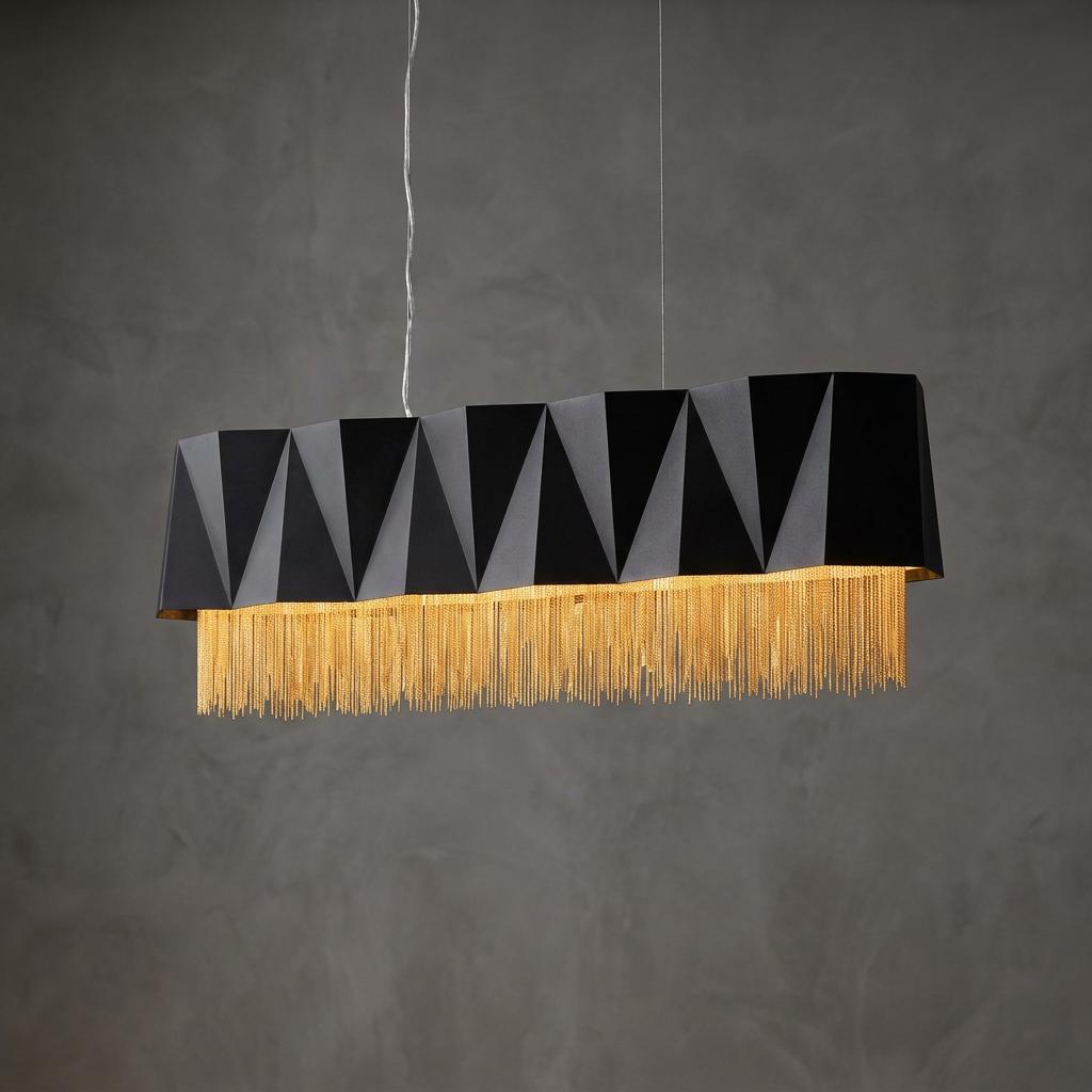 Hinkley Zuma large pendant light with a black geometric shade and gold chain fringe against a textured grey wall.
