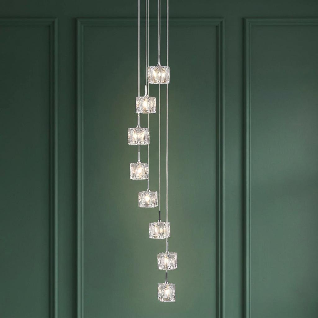 Eight ice cube glass pendants cascading in a spiral against a dark green paneled wall.