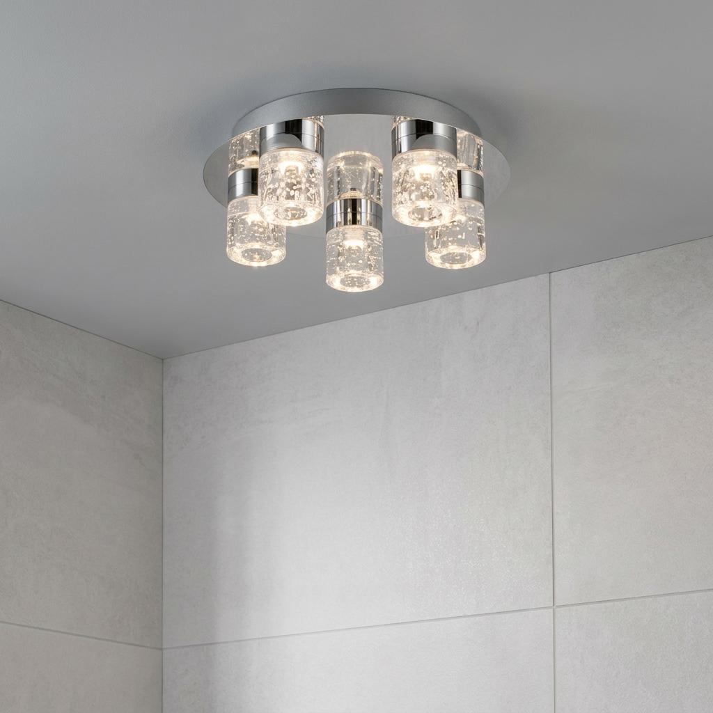 Modern 5-light chrome bathroom ceiling fixture with bubble glass cylinders mounted on a grey ceiling.