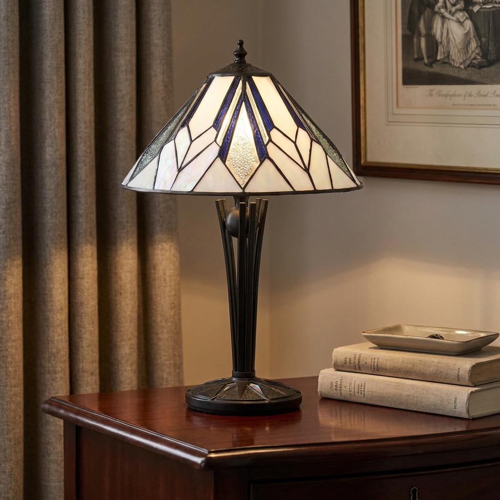 Art Deco Tiffany lamp with a blue and white geometric shade lit on a dark wooden table.