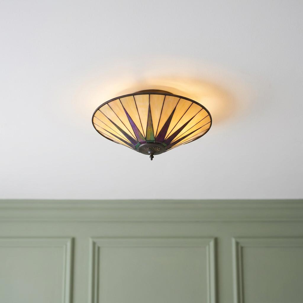 Large Tiffany flush mount ceiling light with an iridescent starburst pattern on a cream glass shade.