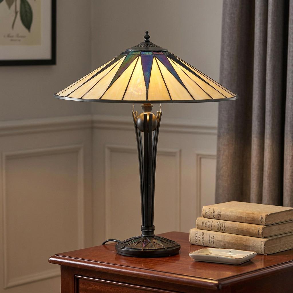 Tiffany table lamp with cream and iridescent blue star glass shade on a bronze base, glowing on a wooden side table.