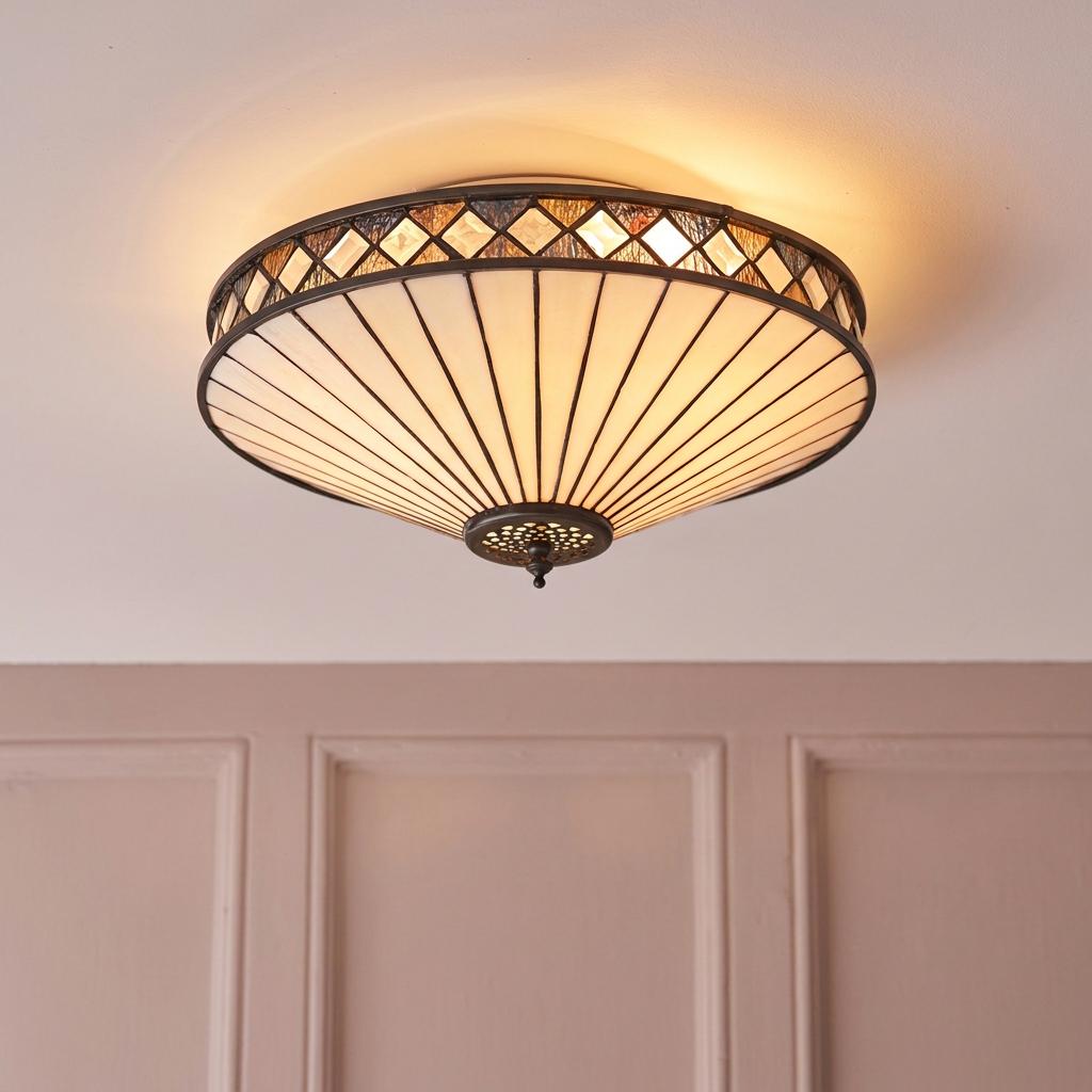 Art Deco Tiffany flush ceiling light with cream glass panels and a decorative diamond border, illuminated.