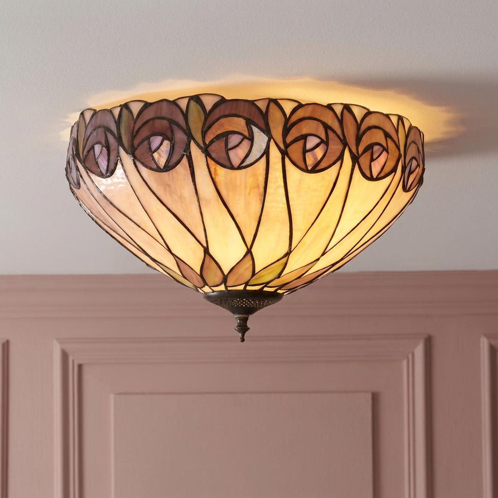 Hutchinson Tiffany flush ceiling light with stained glass rose patterns, glowing warmly above a pink paneled wall.