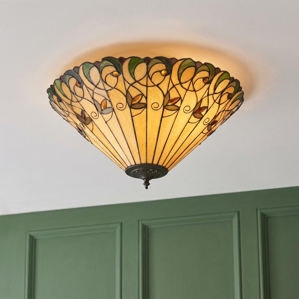 Jamelia flush Tiffany ceiling light with cream leaded glass and green leaf patterns on a white ceiling.