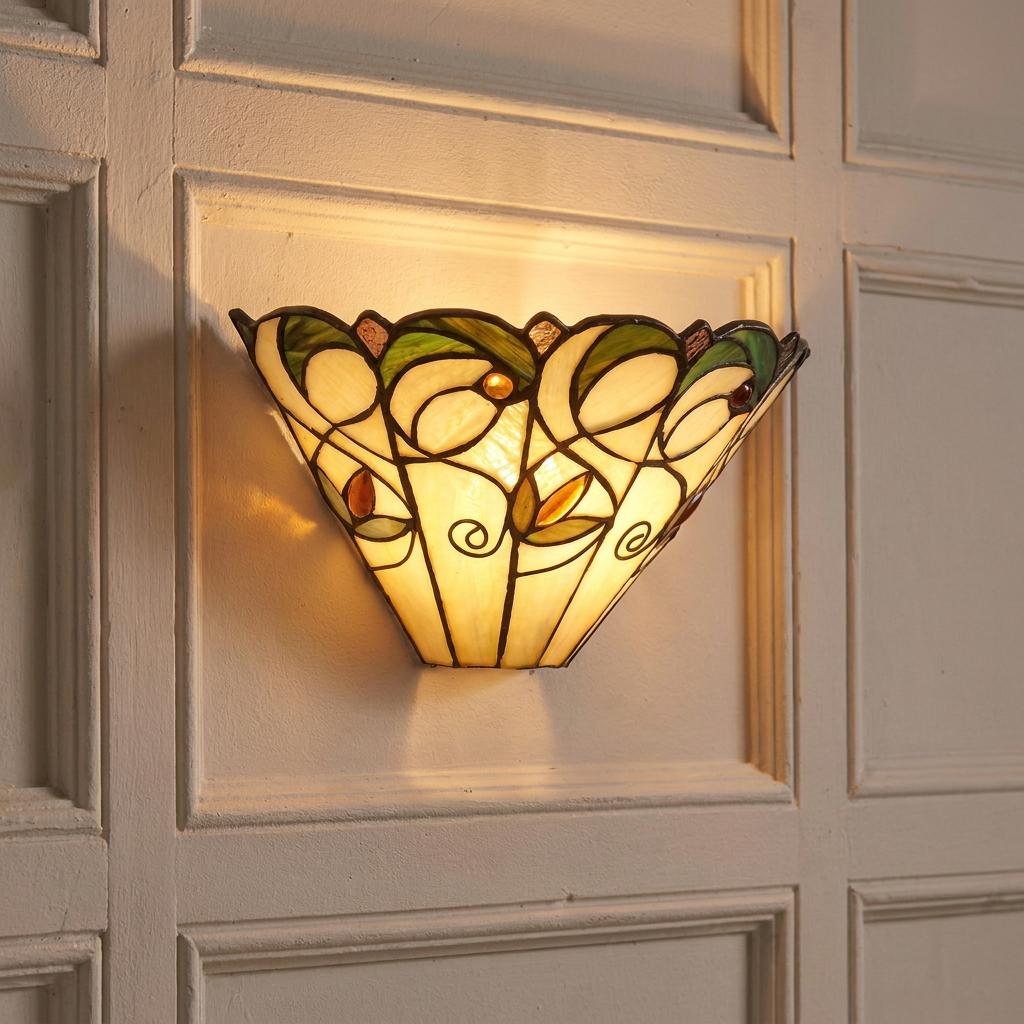 Illuminated Tiffany wall sconce with floral patterns on a cream wood-paneled wall.