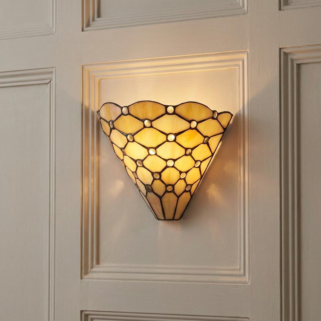 Fan-shaped Pearl Tiffany wall light with a glowing leaded glass pattern mounted on a cream paneled wall.