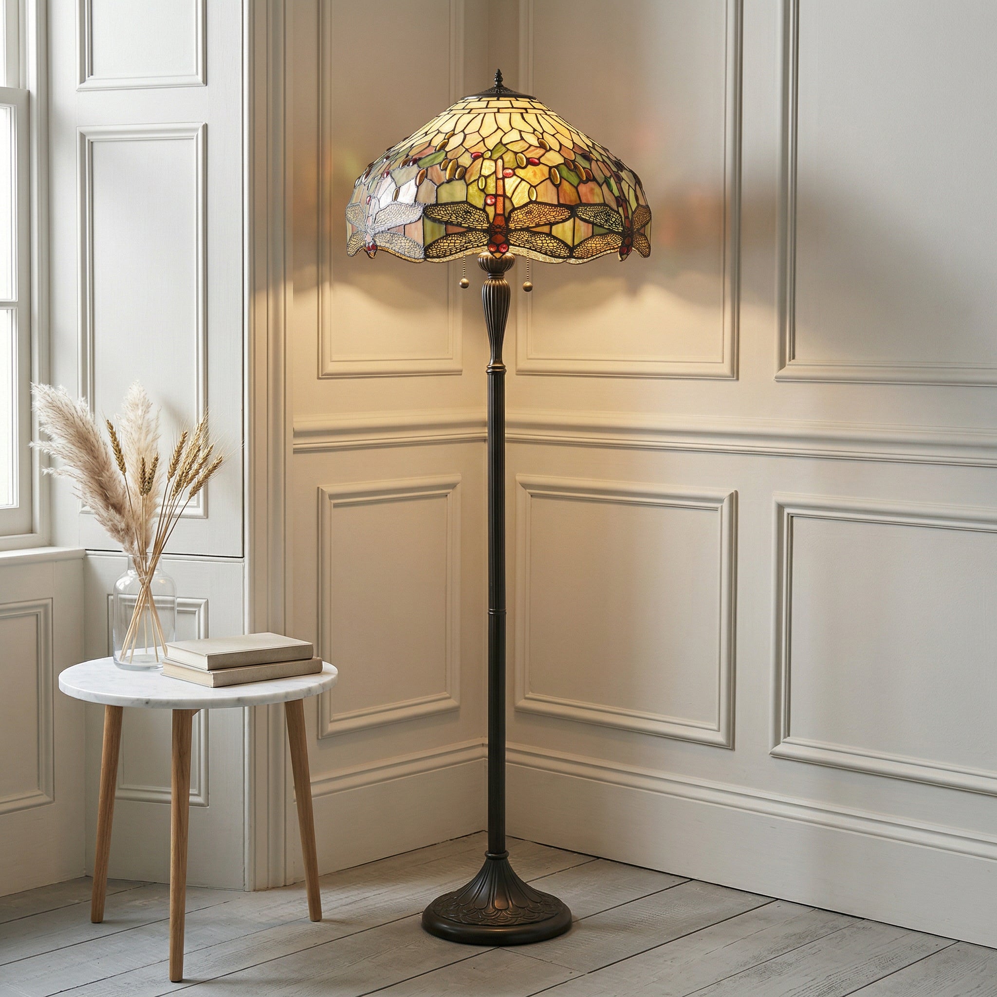 Tiffany-style floor lamp in a room with decorative wall paneling and a small table.