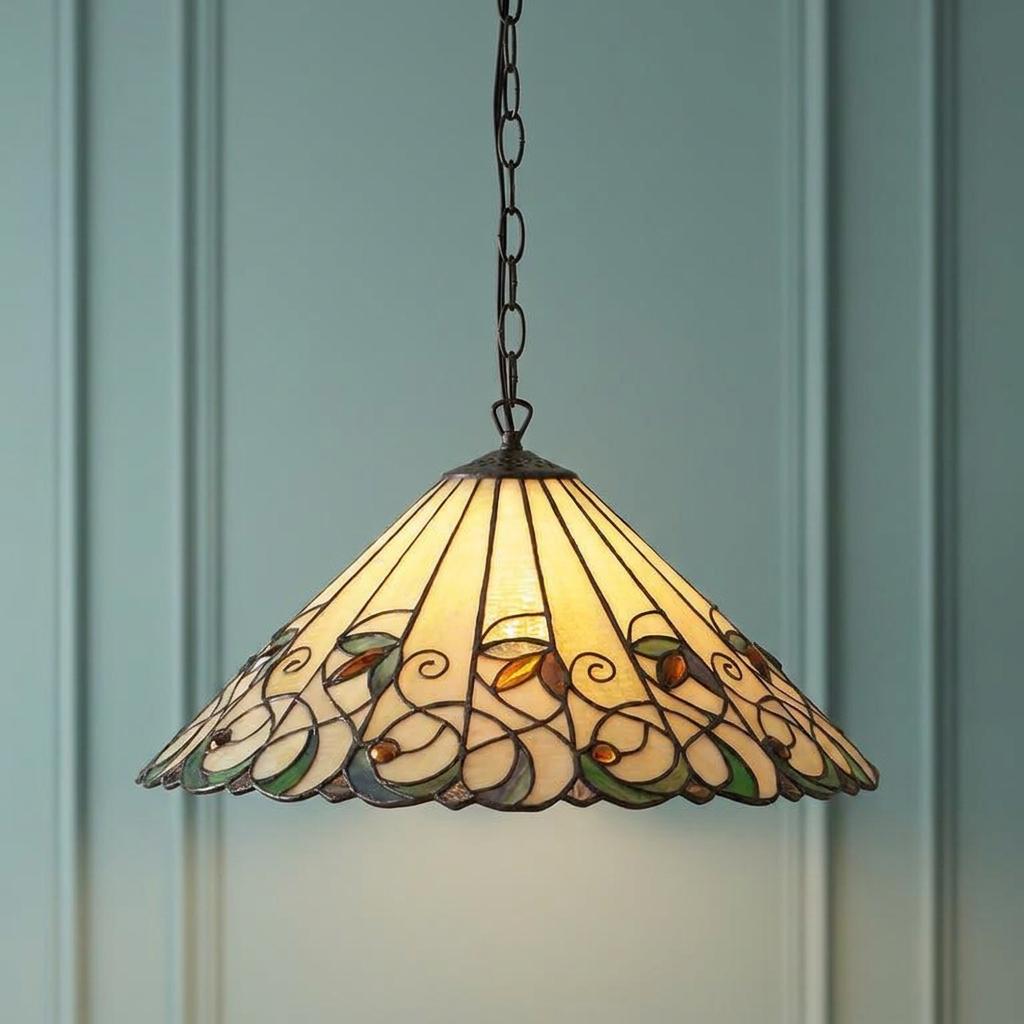 Large Tiffany-style pendant light with cream glass and floral border against a teal paneled wall.