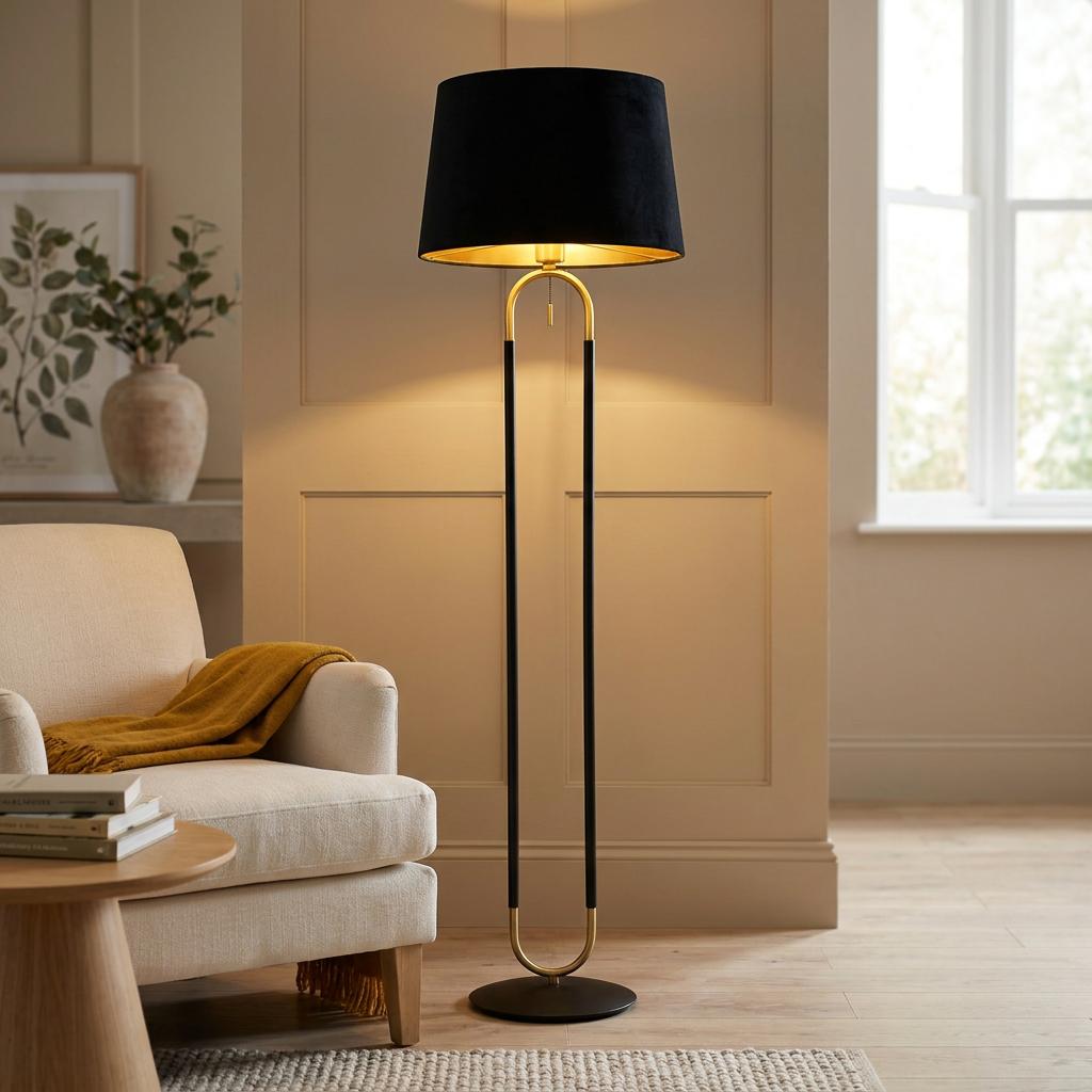 Modern brass and black floor lamp with a black velvet shade in a warm living room setting.