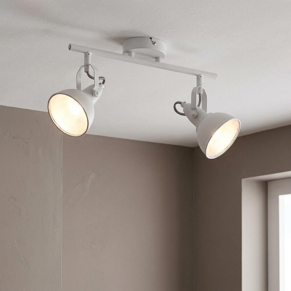 White double bar spotlight with two adjustable heads and warm gold interiors on a white ceiling.