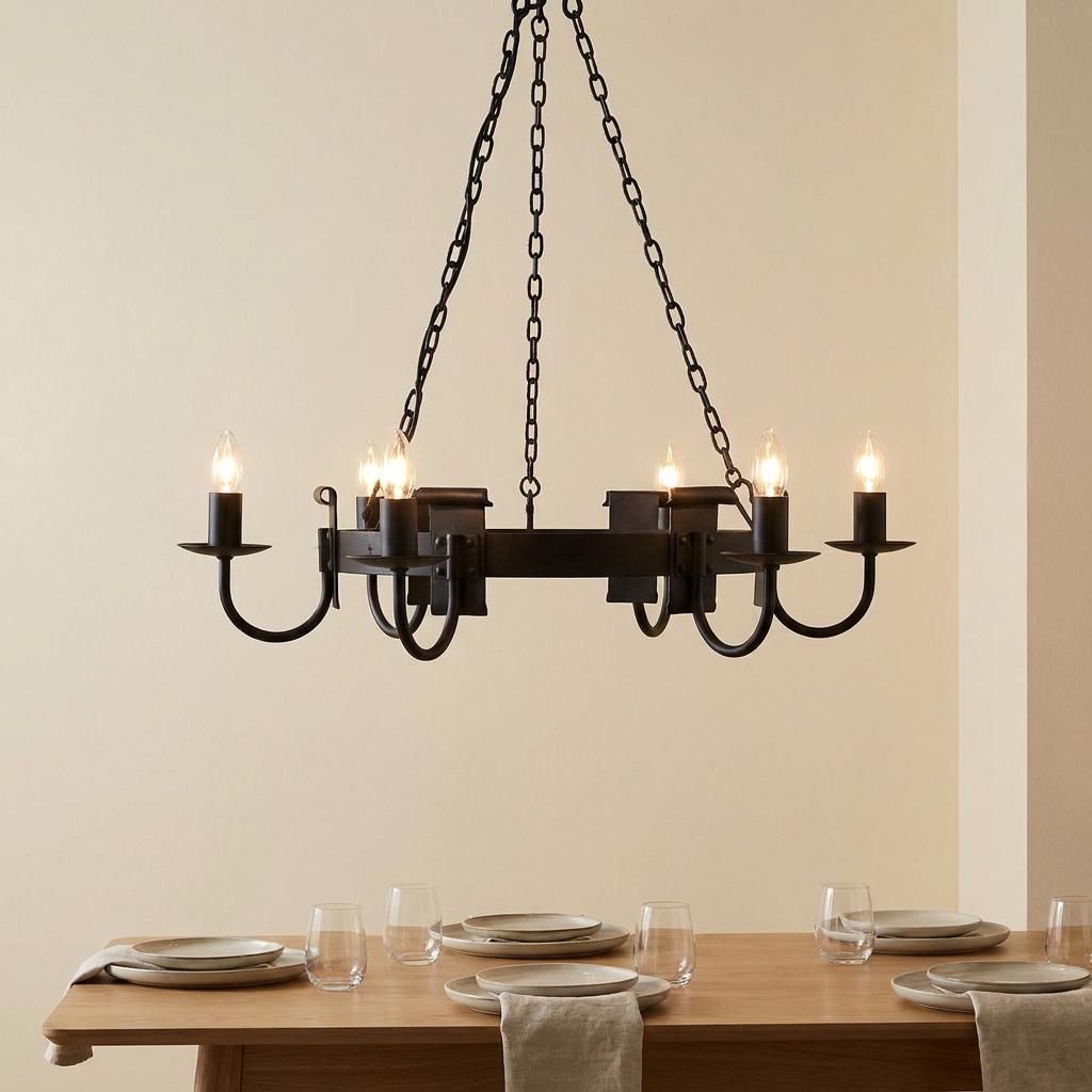 Rustic black 6-arm chandelier with candle lights suspended over a set dining table in a neutral room.