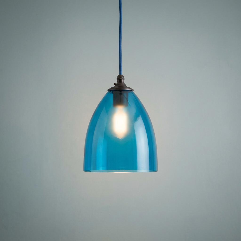 Sky blue Havana glass pendant light illuminated against a grey background.