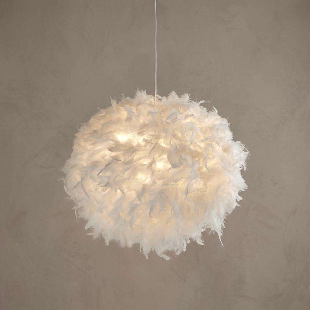 Illuminated spherical white feather pendant lamp shade hanging from a cord against a neutral wall.