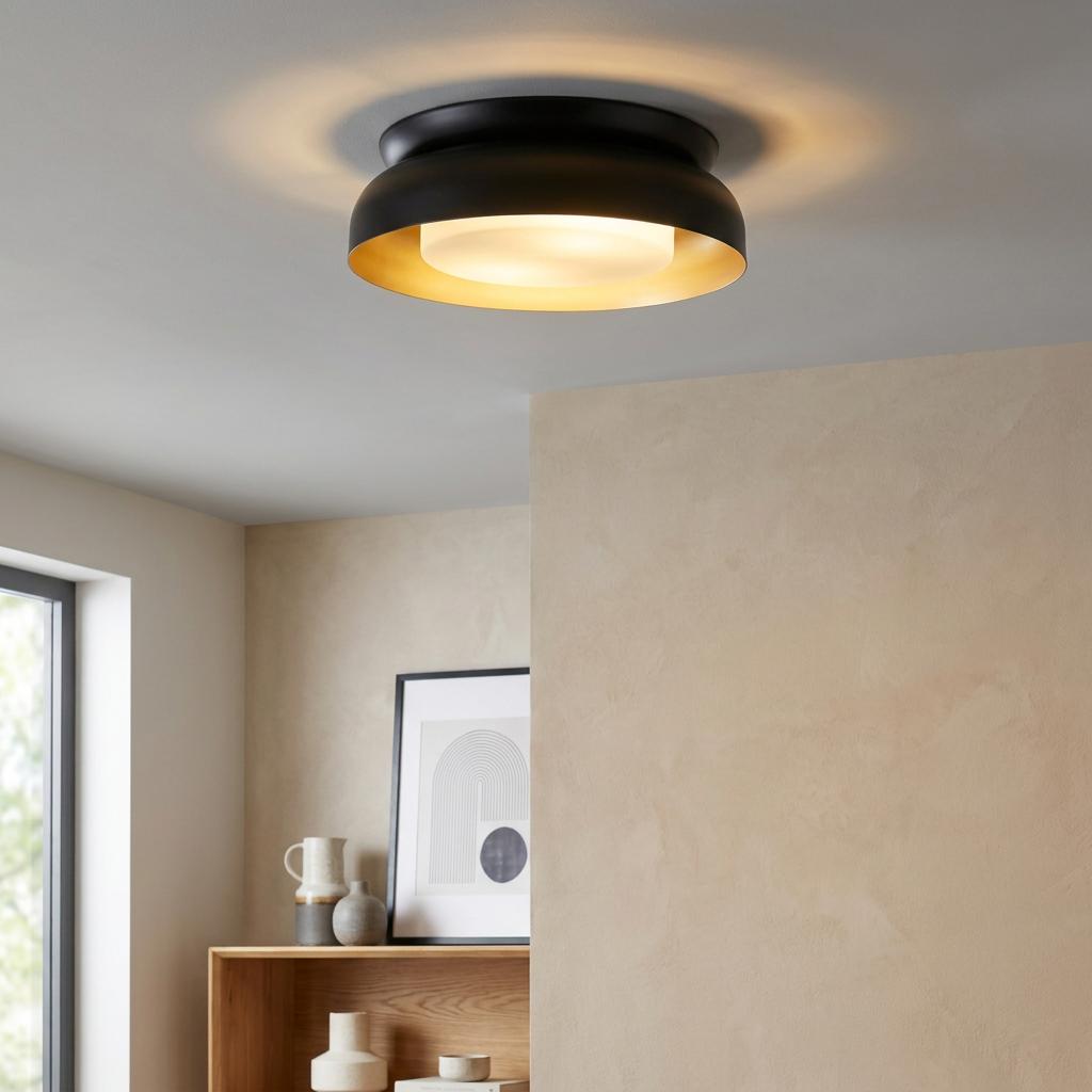 Illuminated black and gold flush ceiling light with a frosted diffuser in a contemporary neutral-toned room.
