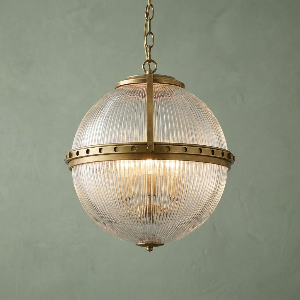 Kichler Aster 3 Light Natural Brass Ceiling Pendant with a ribbed glass globe against a textured green wall.