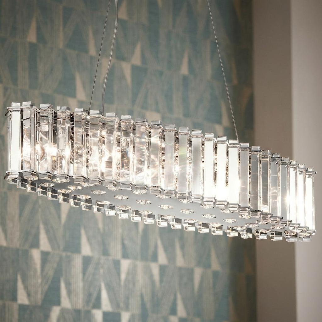 Oval Kichler Crystal Skye island pendant ceiling light with vertical glass rods illuminated against blue wallpaper.