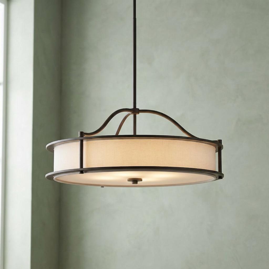 Bronze 4-light semi-flush chandelier with a fabric drum shade hanging against a sage green wall.