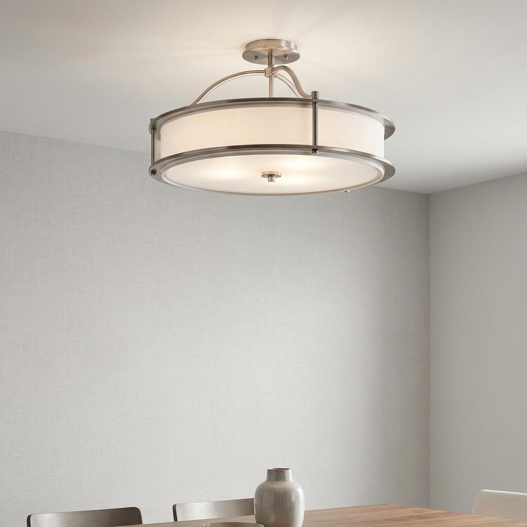 Kichler Emory 4-light semi-flush drum chandelier with a pewter frame and off-white shade over a dining table.