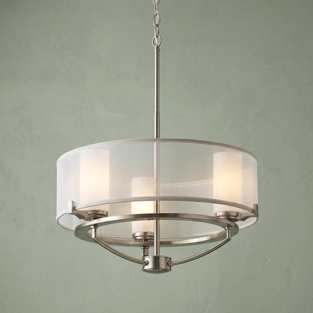 Kichler Saldana 3-light pendant with pewter finish and white fabric drum shade against a green wall.
