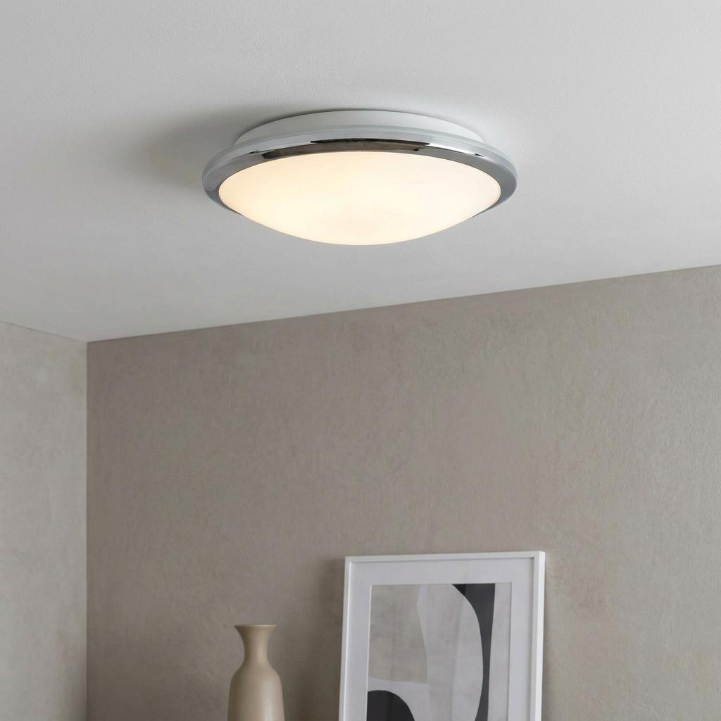 Knutsford flush ceiling light with chrome trim and frosted glass dome illuminated on a white ceiling.