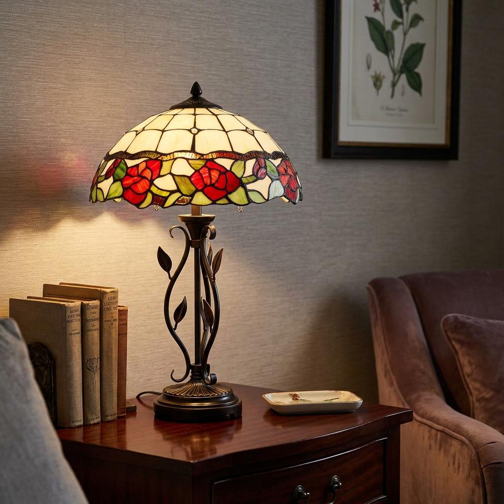 Tiffany table lamp with a red rose stained glass shade and ornate metal base on a wooden side table.