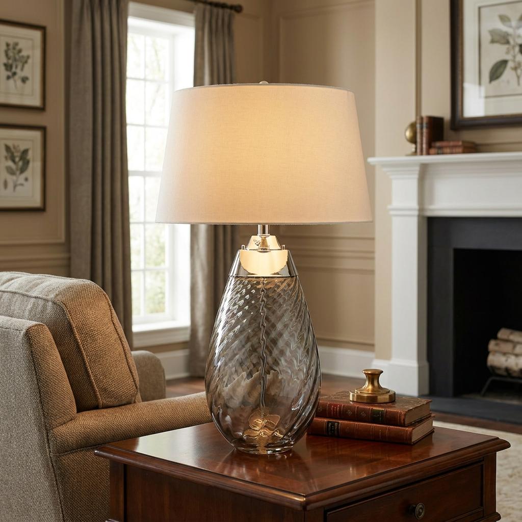 Smoke glass table lamp with a swirled base and off-white shade on a wooden side table in a living room.