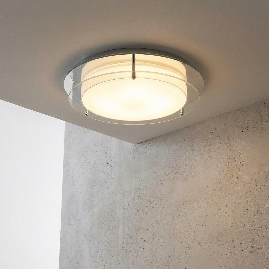 Limerick flush chrome and glass bathroom ceiling light glowing in a minimalist interior setting.