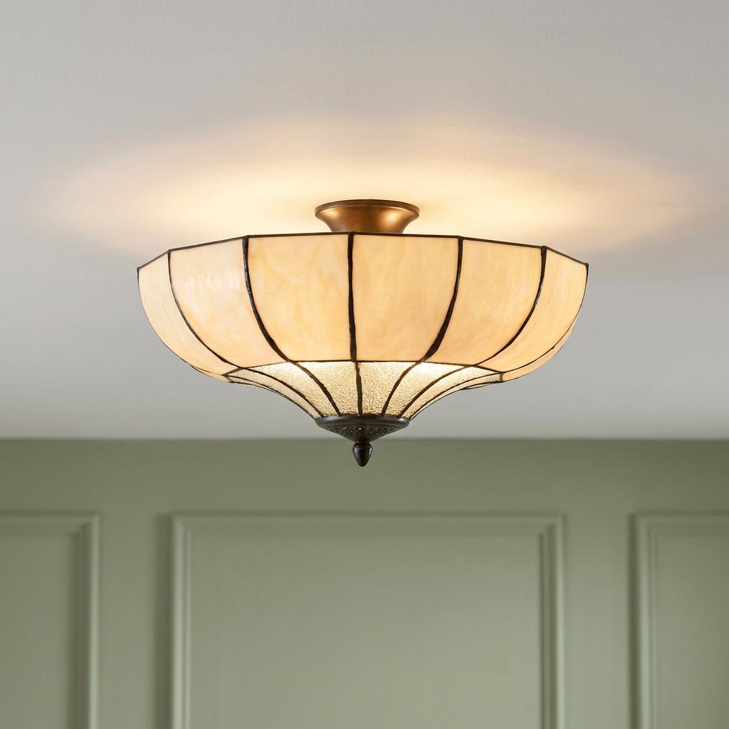 Art Deco semi-flush Tiffany ceiling light with amber glass panels glowing in a room with green panelled walls.