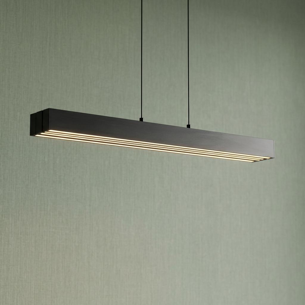 Modern linear matt black LED pendant light with glowing strips against a textured green wall.